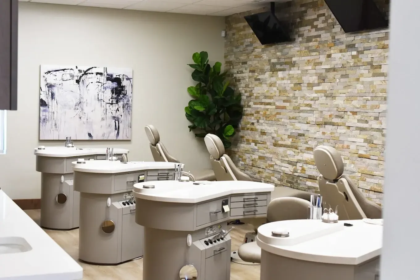 McKay Orthodontics open treatment bay with modern chairs and a stone accent wall